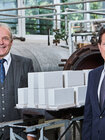 Frederic Dörlitz, Vorstandsvorsitzender, und Roland Meißner, Geschäftsführer des Bundesverbandes Kalksandsteinindustrie e. V., in einem Kalksandsteinwerk vor Produktionsanlagen und Kalksandsteinen.