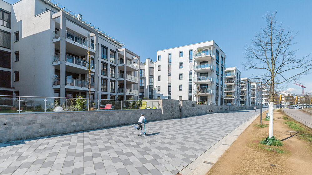 Wohngebäude am Mainzer Rheinufer mit Uferpromenade, hellen Fassaden und Balkonen