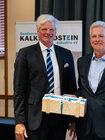 Dr. Hannes Zapf hält bei der Mitgliederversammlung 2026 des Bundesverbands Kalksandsteinindustrie e.V. eine Ehrenurkunde und ein Geschenk in den Händen.