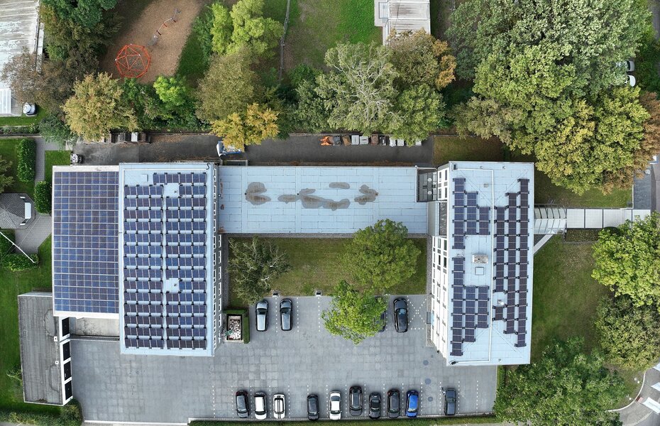 Luftaufnahme des Kalksandstein-Verbandsgebäudes in Hannover mit Parkplatz und begrüntem Umfeld – Standortbeispiel für klimafreundliche Energieversorgung durch Photovoltaik im Rahmen der regionalen Energiewende